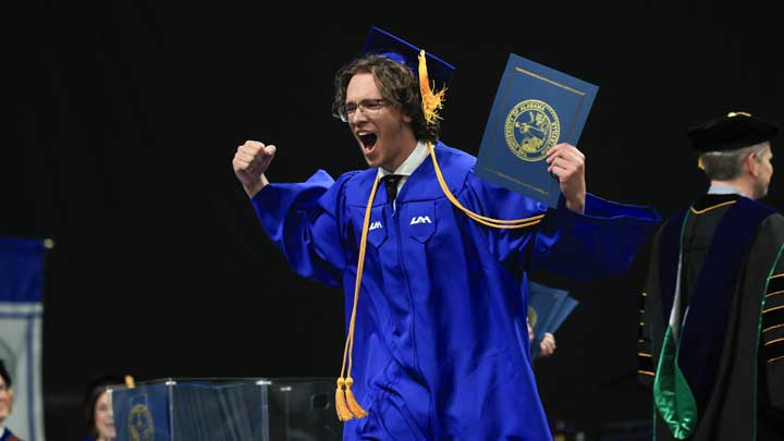 UAH graduate receiving diploma from The University of Alabama in Huntsville during commencement ceremonies on May 4, 2026