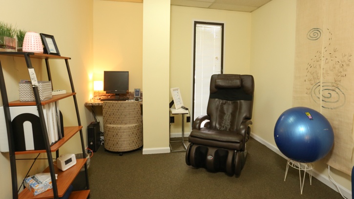 A room with a massage chair and meditation equipment