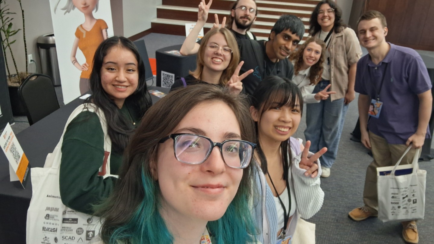 images/colleges/arts-humanities-social-sciences/students_in_the_lobby_of_the_animation_yall_conference_smiling_with_other_attendees.jpg