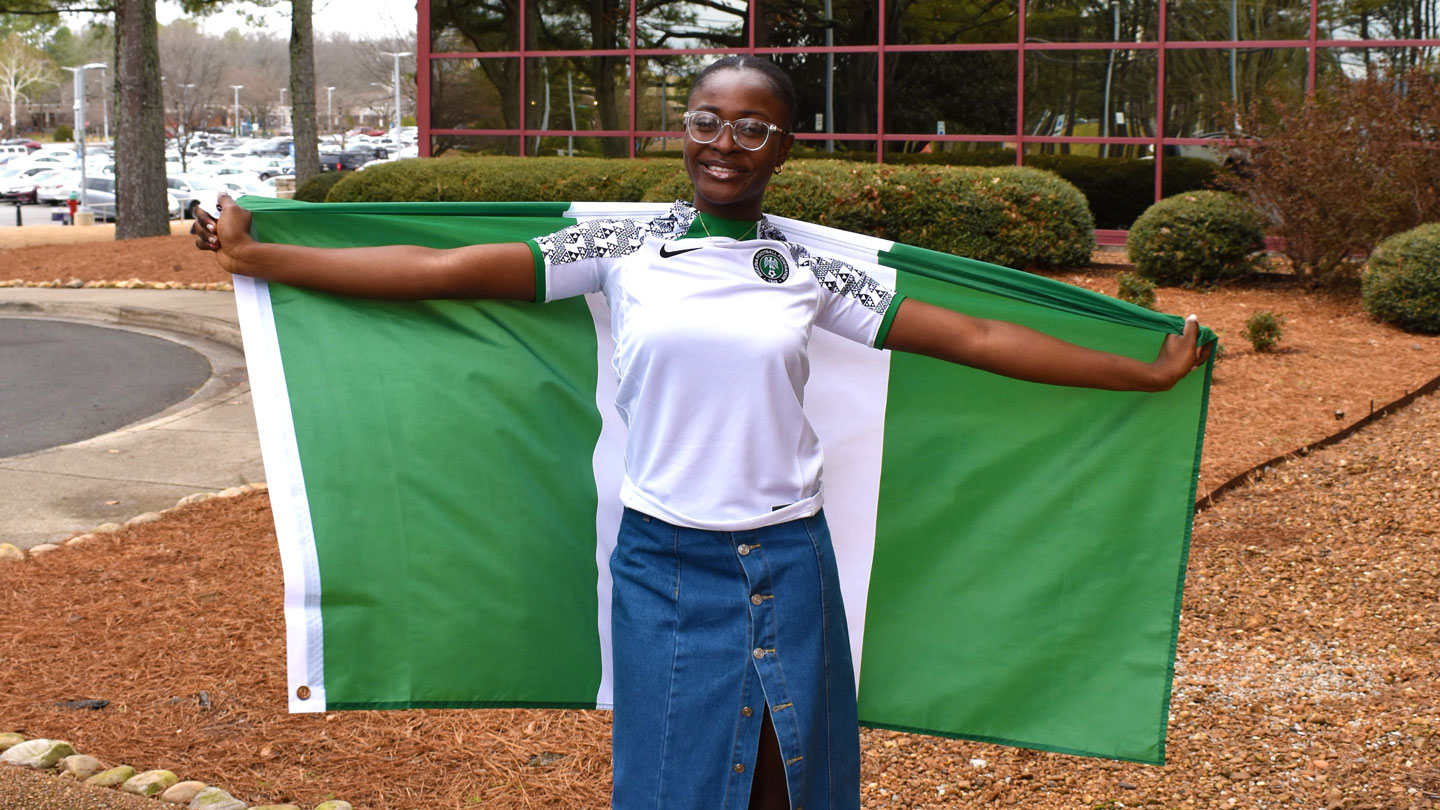 Ore Isola holding the flag of Nigeria stretched behind her.