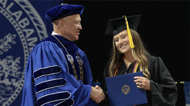 dr. karr shaking hands with a uah graduation during commencement