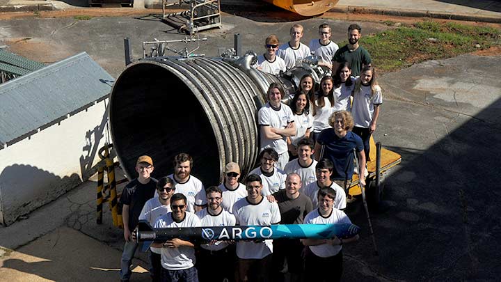 The Charger Rocket Works student team posing new a rocket engine