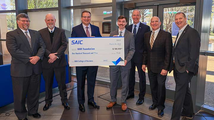 group of men in suits accepting a check