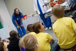 A nurse interacts with kids at the Let's Pretend Hospital.