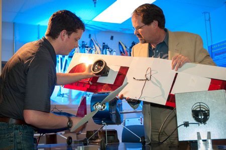 Mechanical Engineering student Josiah Thomas (left), and Dr. D. Brian Landrum, associate professor of Aerospace Engineering at UAH, discuss placement of a solar blind fire sensor on a UAV (unmanned aerial vehicle).