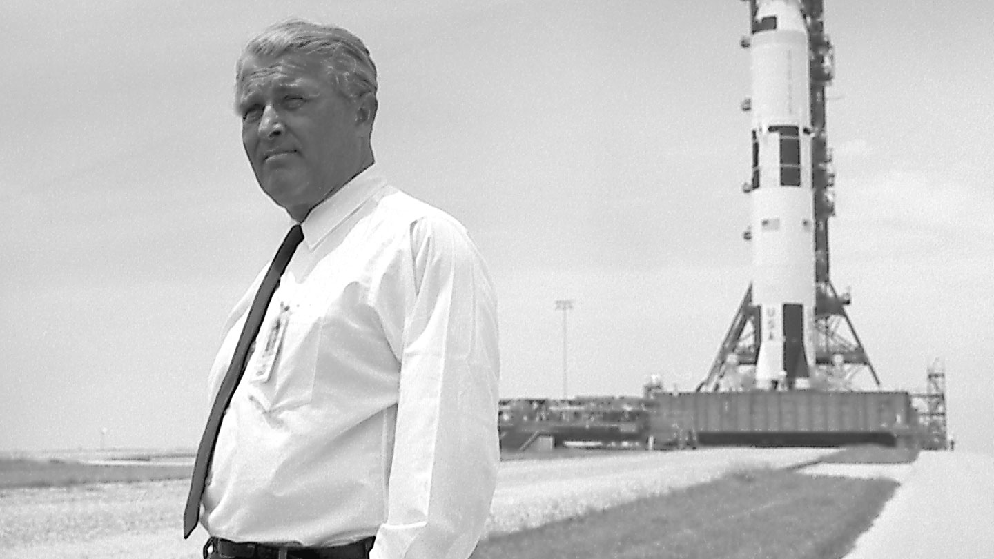 Wernher von Braun pauses in front of the Saturn V