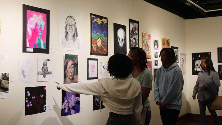 Attendees at the 2024 event view works of art in the Wilson Hall Gallery