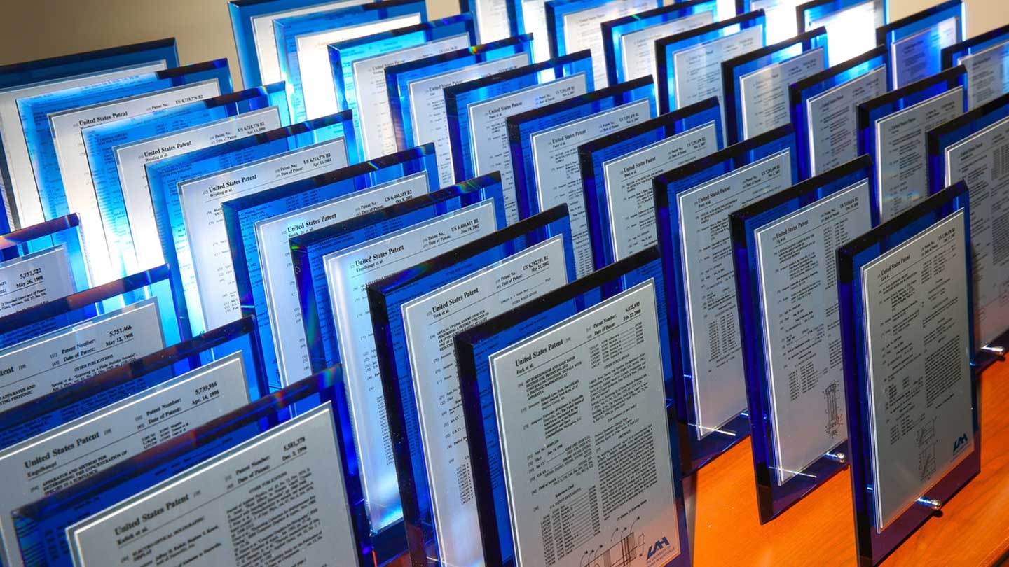 Rows of UAH patent awards on a table.