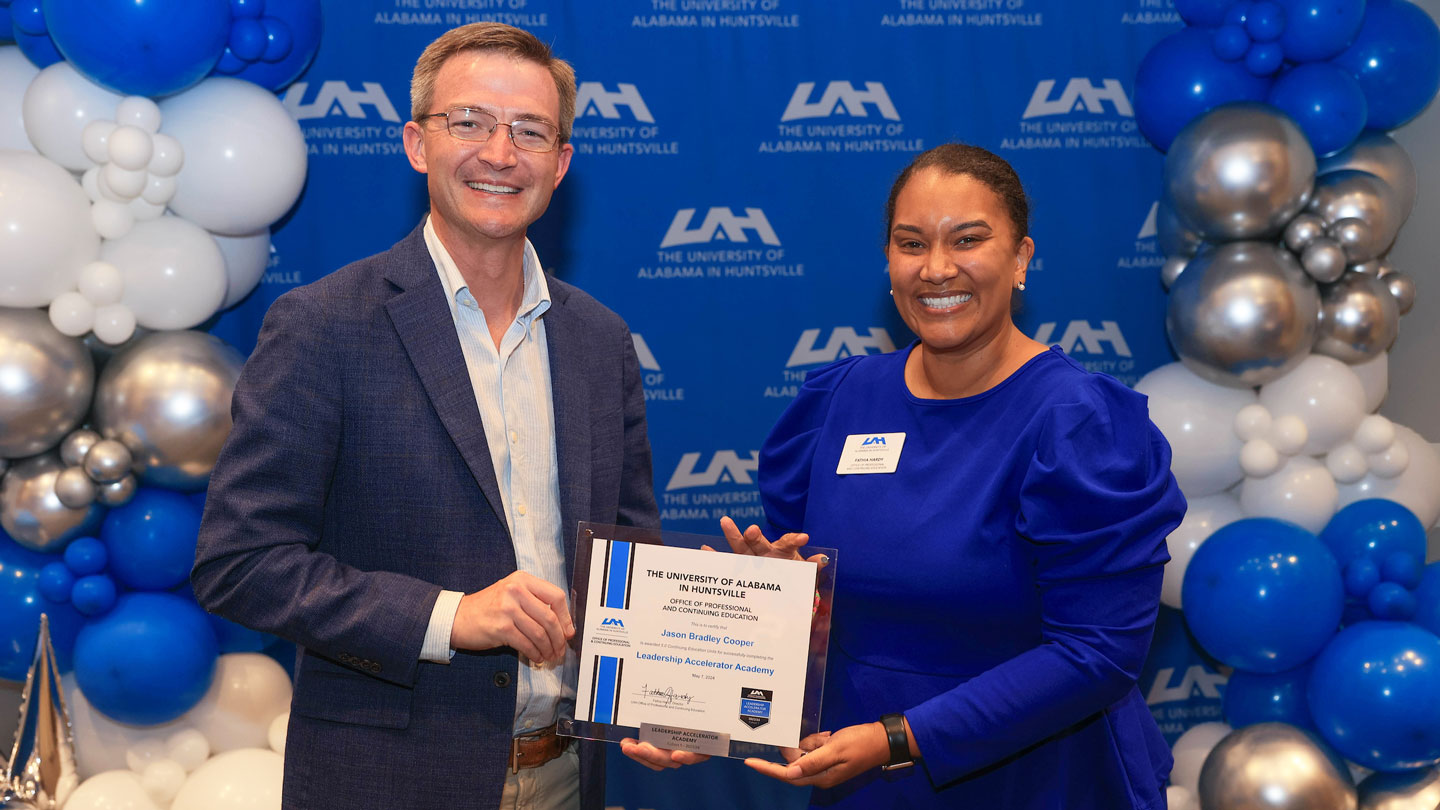 O P C E director Fathia Hardy presents a leadership certificate to Jason Bradley Cooper