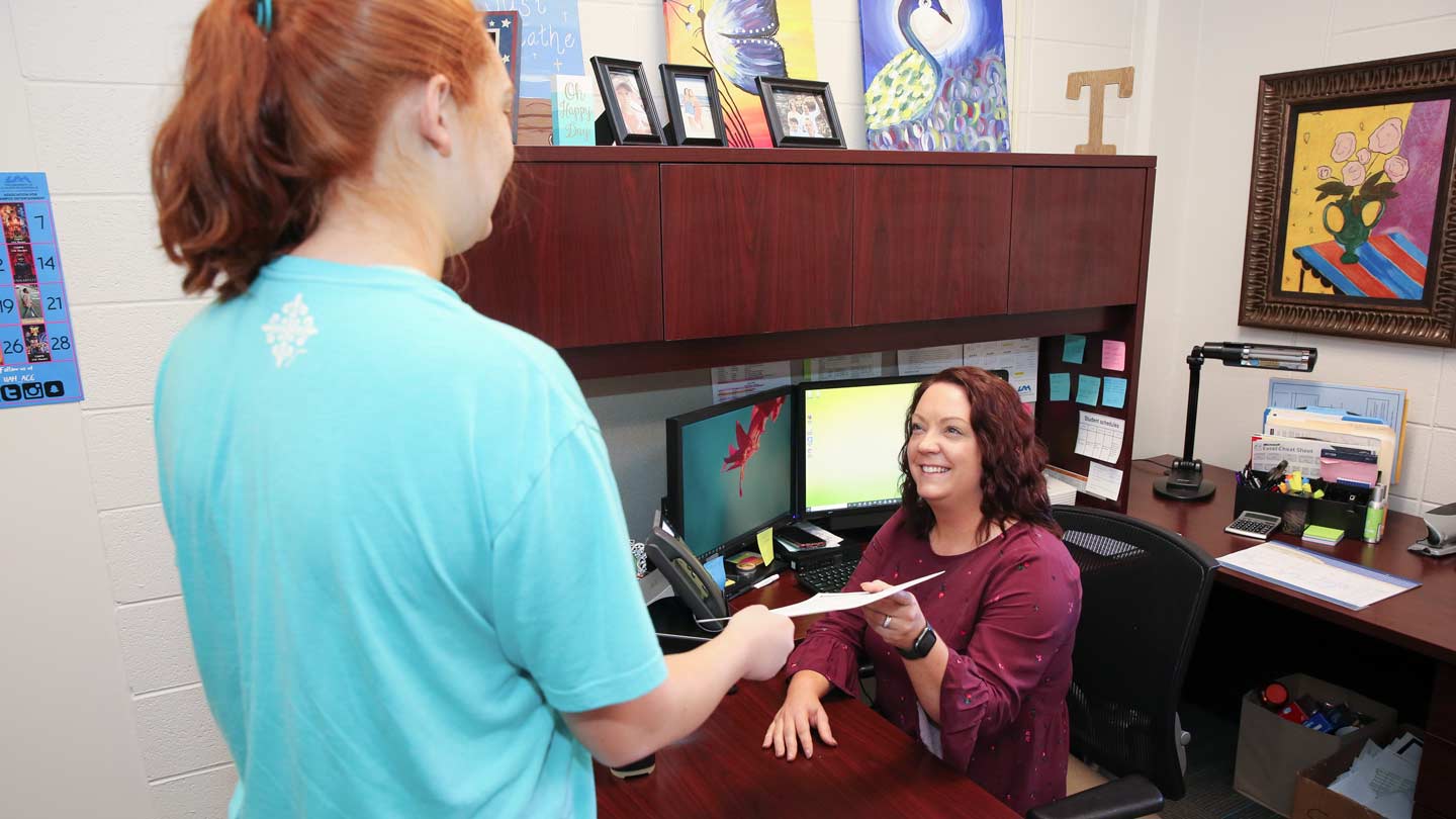 A student checks in with a receptionist at the U A H Student Health Clinic