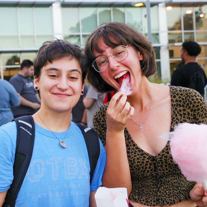 Two freshmen U A H students smile and share some cotton candy