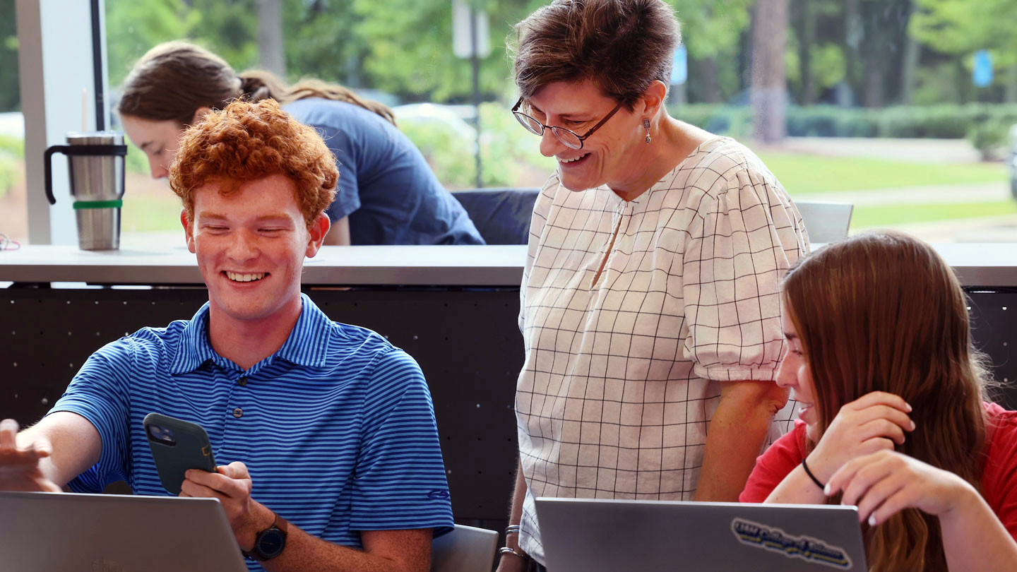 A teacher works with a writing student on his essay.