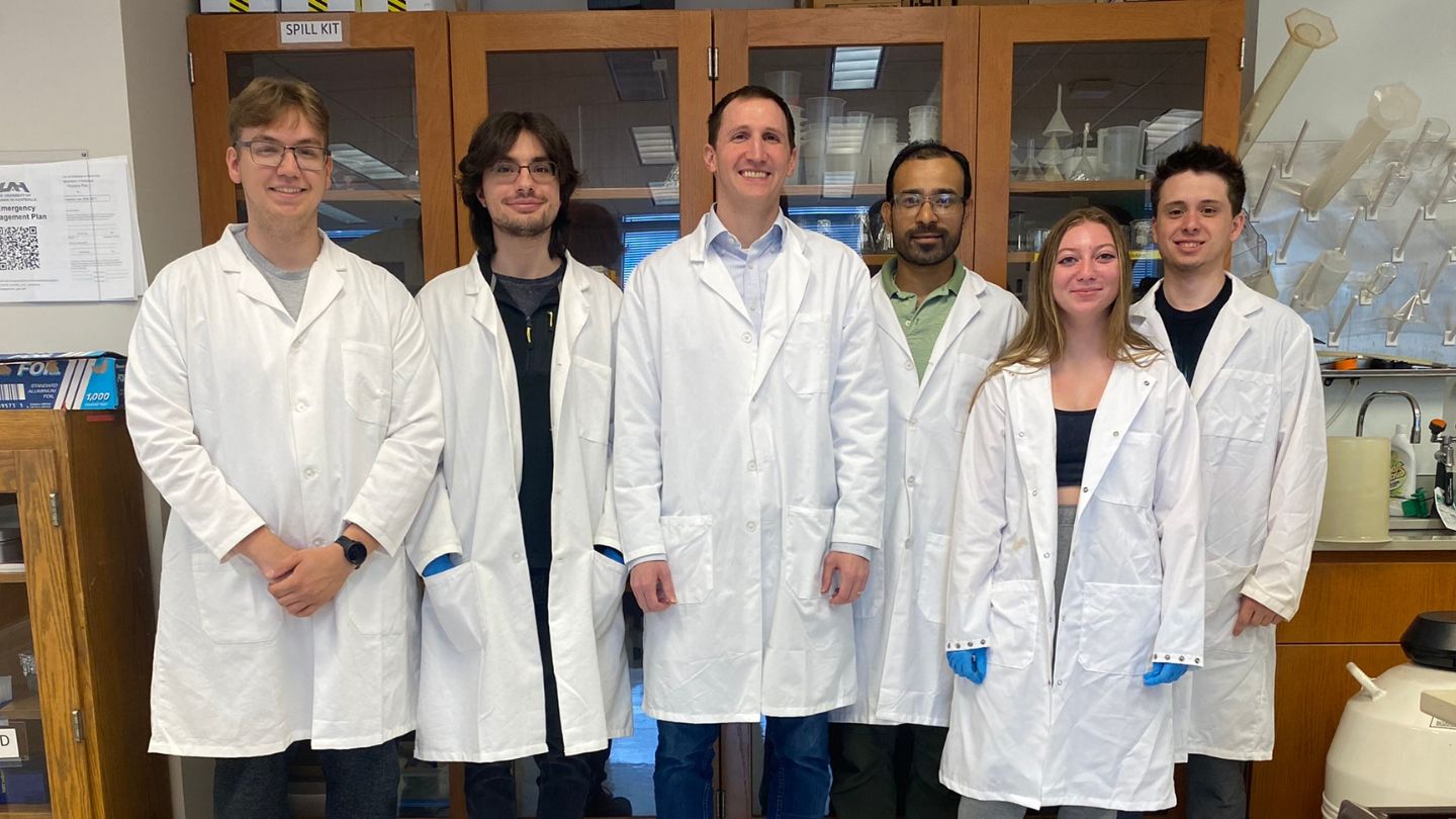 Dr. Bradley R. Kraemer alongside students from the College of Science within his research laboratory.