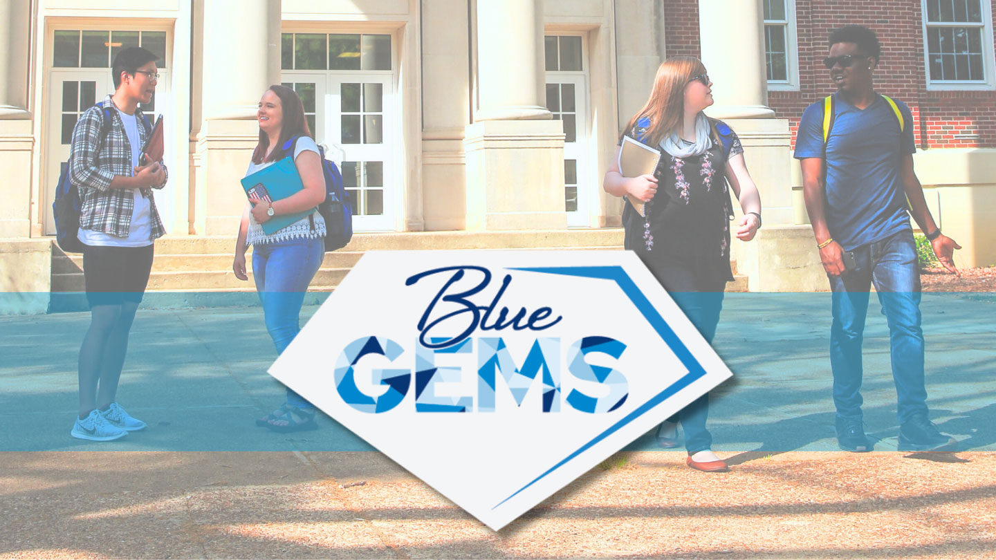 a group of UAH students representing Blue Gems Society walking in front of a building