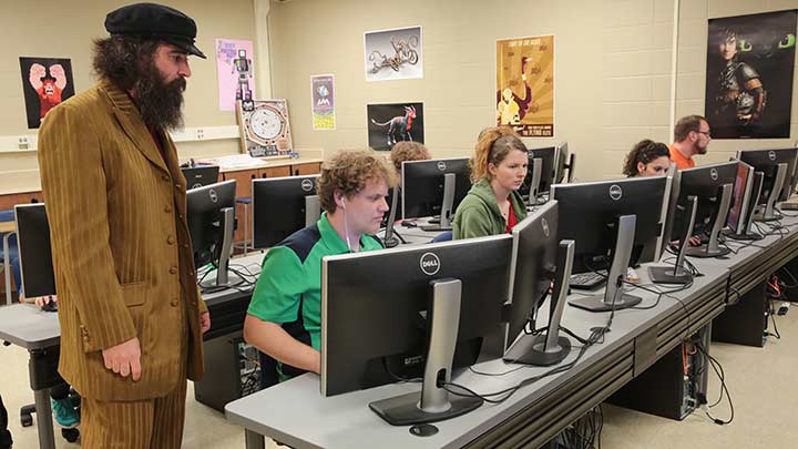 Vinny Argentina, Associate Professor in Department of Art, Art History & Design, instructs students on their computers