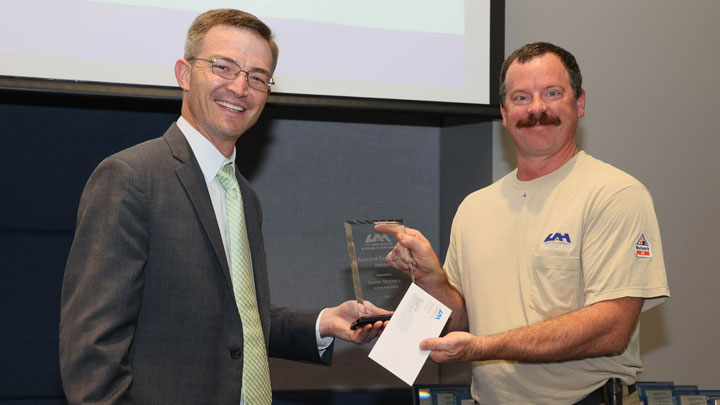 Brad Cooper, assistant vice president, finance and business services/controller, presents Facilities Excellence Award to Jeremy Mitchell
