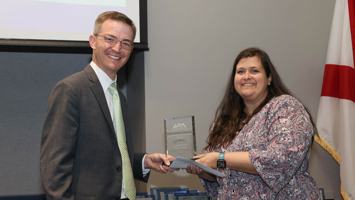 Brad Cooper, assistant vice president, finance and business services/controller, presents Staff Leadership Excellence Award to Amber Adcock
