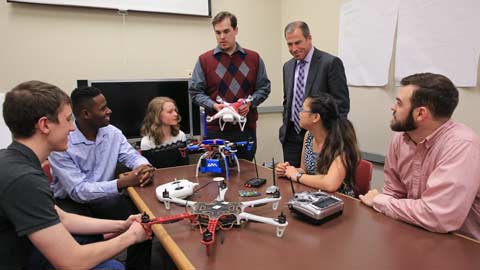A UAH senior design class explains their strategy for drone defense to Bob McCaleb, Northrop Grumman corporate lead executive, at Olin B. King Technology Hall on campus. From left are Daniel Bernues, Tevon Walker, Alyse Adams, William Klingbeil, McCaleb, Faith Buckley and Zack Horvath. 