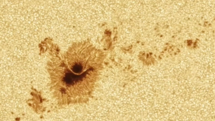 A light bridge, a lane of bright material that often divides the umbra, or central dark region, of a sunspot.